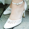 White t-bar shoes beside purple and white bouquet