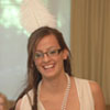 White 1920's-style dress paired with a white feathered dress and pearl necklace