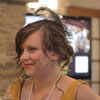 Mustard yellow ruffled dress paired with long white pearl necklace