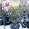Elegant silver-stemmed centrepiece with white and light pink roses and white peonies.