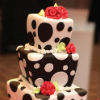 Whimsical black and white polka dot cake with fondant roses and pearl trim