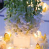 White floral centerpieces with white tea lights and yellow flowers
