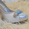 White patent pumps with metallic gold toes and rhinestone toe decal