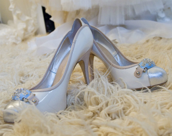 White patent pumps with metallic gold toes and rhinestone toe decal