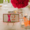 Simple table decor with white and lime green linens and fuchsia flower centre pieces.