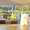 Tented outdoor dance floor with green and white flowers