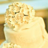 Elegant three tier cake with white rose bouquet topper and white pearl icing trim