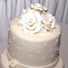 White three tier fondant cake with white fondant ribbon trim & fondant rose topper