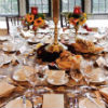 Fall theme décor with orange, yellow & red floral centerpieces