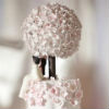 Five tier cake with pink cherry blossom bouquet topper and cherry blossom petal detail