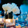 White rose centerpieces, wine bottles and pink flower petal accents