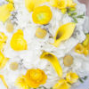 Fresh summer bouquet of yellow roses and calla lillies, white daisies, and additional white floral accents