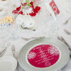 White table decor with red accents in menus, table signs and a red rose centerpieces and 