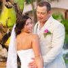 bride and groom standing by a palm tree