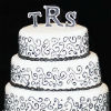 Black and white four tier cake with black buttercream design and monogram inital toppers