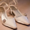 Metallic cream pointed closed toe sandal with round rhinestone decal