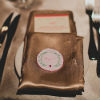 Gold napkin with guest table setting against white table linens