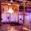 Rustic elegance with purple lighting, clear chairs, tea light lit aisle