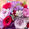 Vibrant summer bouquet with lavender, red and pink roses and accents. 